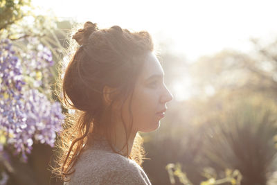 Side view of young woman in park on sunny day