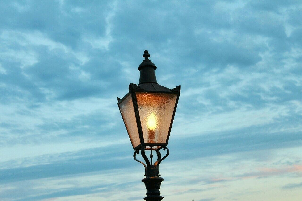 low angle view, sky, cloud - sky, lighting equipment, silhouette, street light, cloudy, cloud, sunset, no people, lamp post, outdoors, nature, built structure, dusk, high section, illuminated, tranquility, sunlight, sculpture