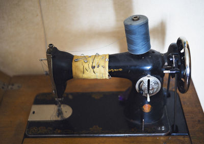 Old old sewing machine. selective focus on details. close up. added gaussian noise.