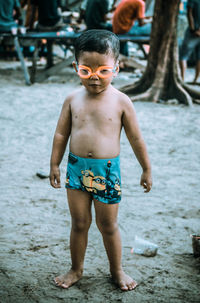 Full length of shirtless boy standing in water