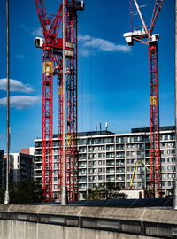 Cranes at construction site against sky