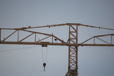 Low angle view of crane against clear sky