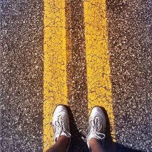 Low section of man standing on road