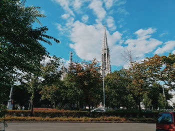 Trees in city against sky