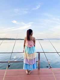 Rear view of woman standing against sea