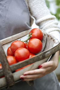 Woman holding basket with tomatoes