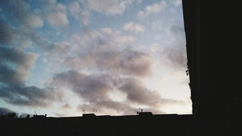 Low angle view of silhouette buildings against sky