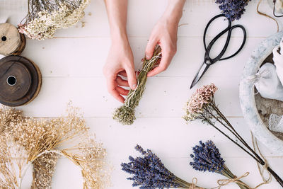 Hands of a florist woman at work. dry compositions of flowers and plants for the interior