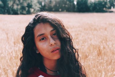 Portrait of beautiful young woman lying on land
