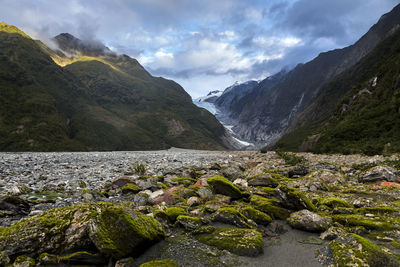 Scenic view of river by mountains against sky