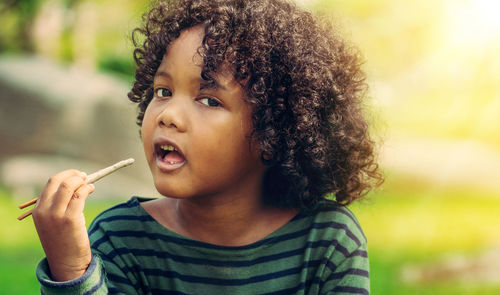 Close-up portrait of cute girl holding dandelion