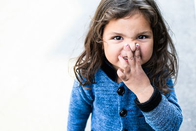 Portrait of girl holding nose 