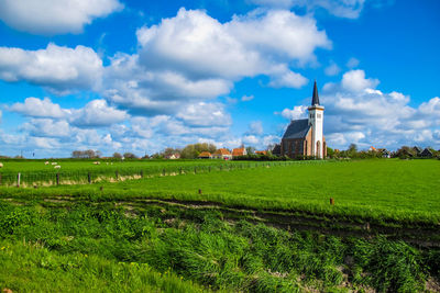 Traditional windmill on field against sky