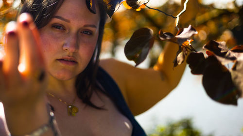 Low angle view of young woman standing against sky