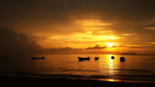 Silhouette boat in sea against sky during sunset