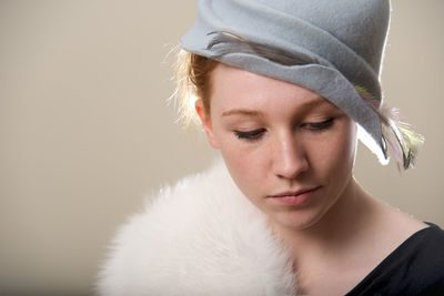 Close-up of young woman looking away against wall