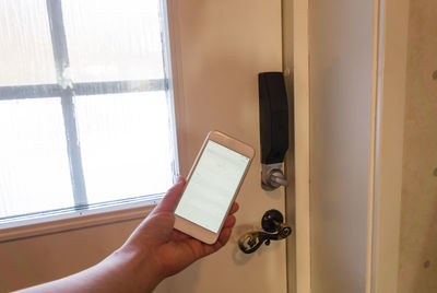 Midsection of person holding window at home