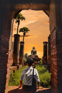 Rear view of men outside temple against building