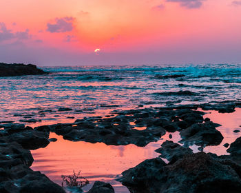 Scenic view of sea against orange sky