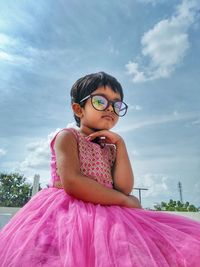 Portrait of a girl with pink face against sky