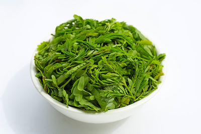 High angle view of vegetables in bowl against white background