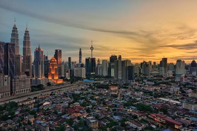 Aerial view of buildings in city during sunset