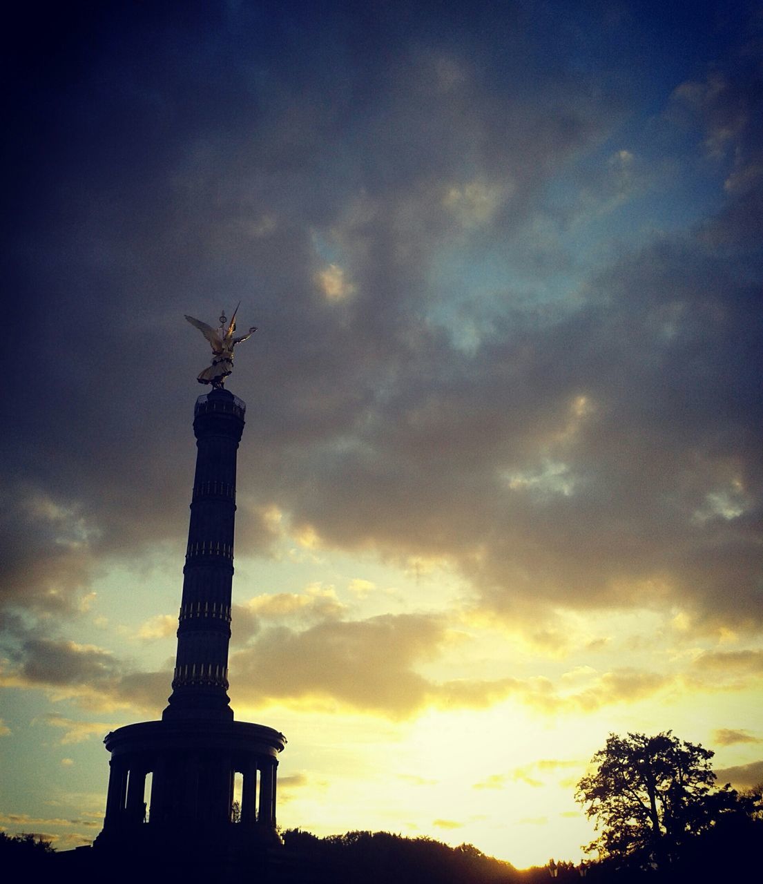 low angle view, sky, statue, sculpture, religion, human representation, silhouette, cloud - sky, built structure, architecture, spirituality, art and craft, art, history, sunset, place of worship, creativity, travel destinations