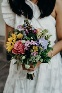 Midsection of woman holding flower bouquet