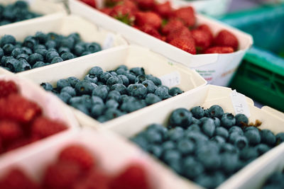 Close-up of berry fruits in container at market stall