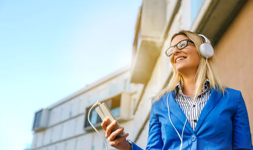 Low angle view of young woman using mobile phone