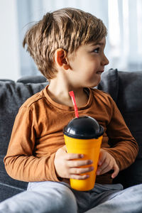 Boy sitting on sofa at home