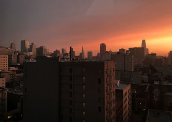 Modern buildings against sky during sunset