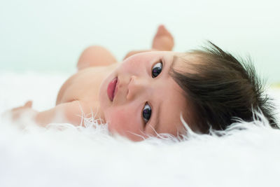 Portrait of cute baby boy lying on bed