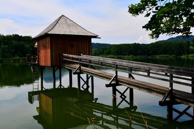 Built structure by lake against sky