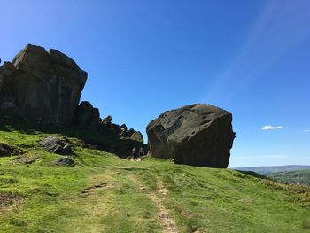 Rock formations on landscape against blue sky