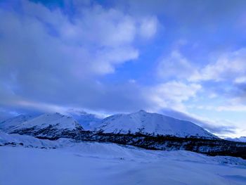 Scenic view of snowcapped mountains against blue sky