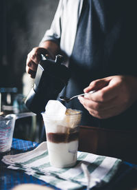 Midsection of man holding coffee cup