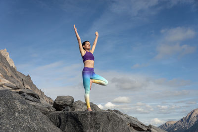 Yoga woman doing tree pose. meditation and balance exercise in beautiful nature mountain landscape