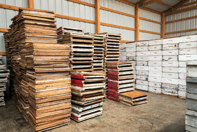 Stack of wooden pallets by beehives in storage room