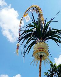 Low angle view of palm trees against cloudy sky