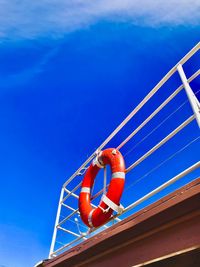 Low angle view of life belt on railing of nautical vessel against sky