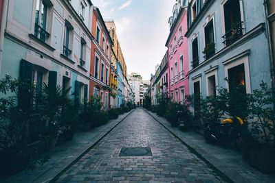 Street amidst city against sky