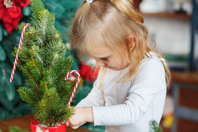 Side view of girl playing with christmas tree