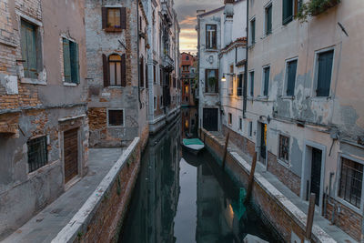 Boats in canal amidst buildings in city