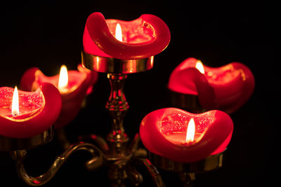 Close-up of burning candle against black background