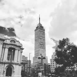 Low angle view of skyscrapers against cloudy sky