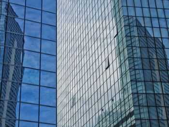 Low angle view of glass building against sky