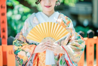 Midsection of woman holding umbrella