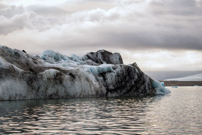 Icebergs in sea against sky