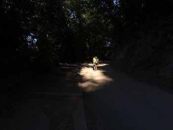 Man riding woman walking on road